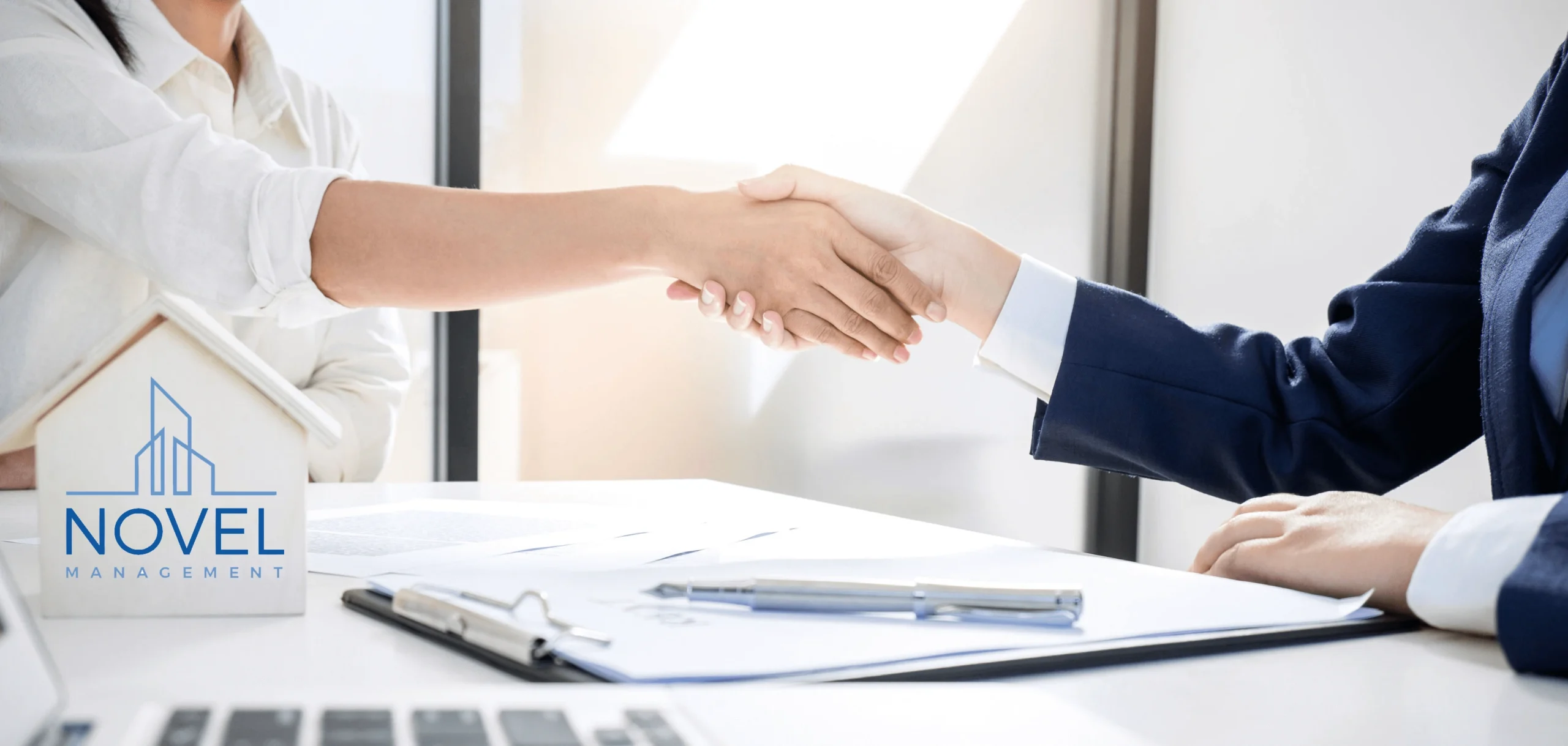 Handshake beside a Novel Management sign